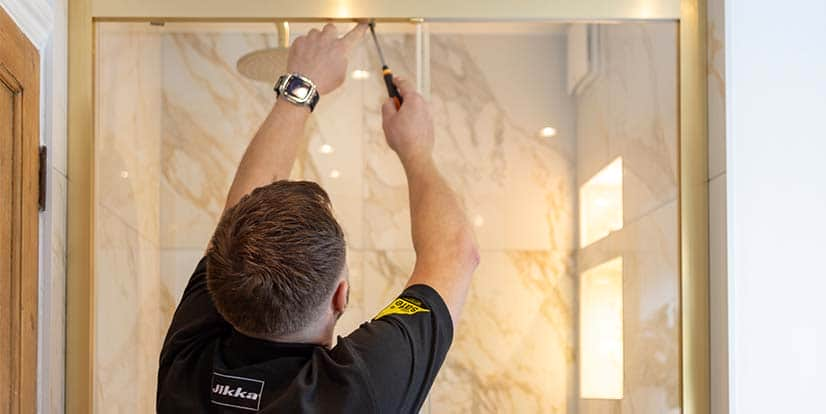 A staff member of Jikka carrying out installation activity in the bathroom