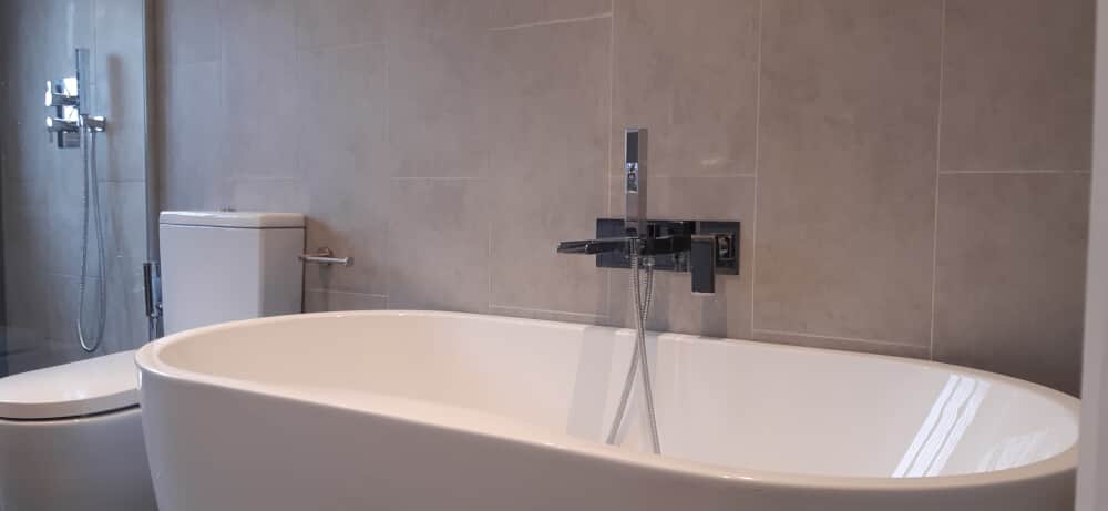 Close look of the bathtub with a water closet by its side - Bathroom fitters Bromley by Jikka