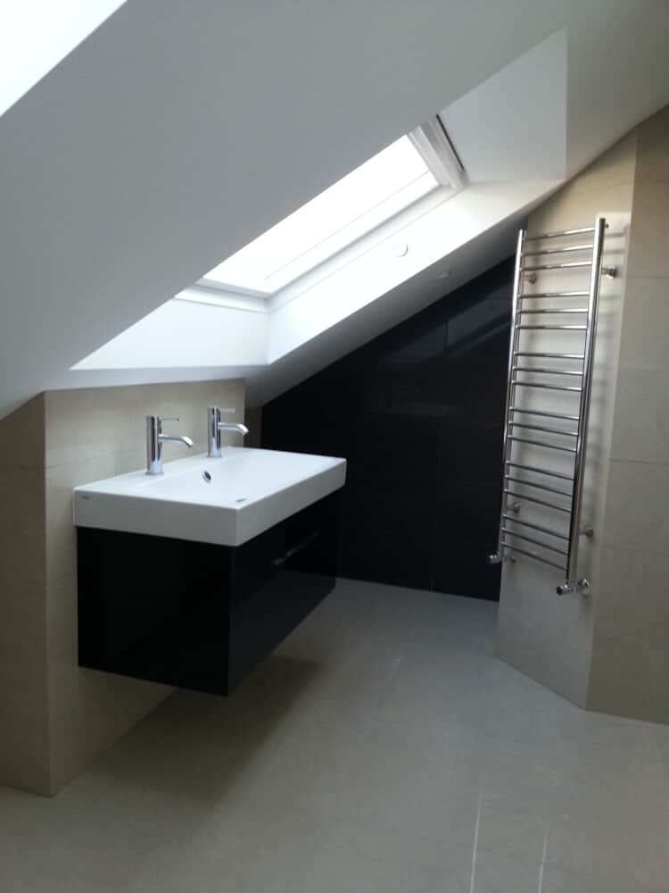 Wall mounted wash basin with two taps and a towel rack by its side by Jikka - Bromley Bathroom Company