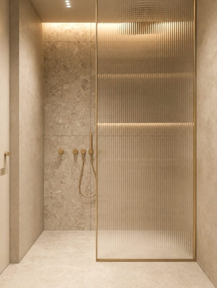 Walk-in shower with fluted glass screen and brass fittings, installed by Jikka in Kent